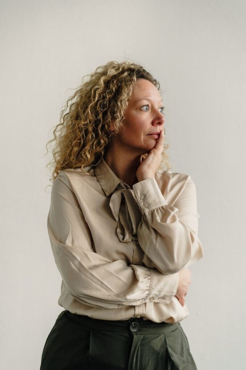 Sofie Jamers, in gedachten, tegen een lichte muur